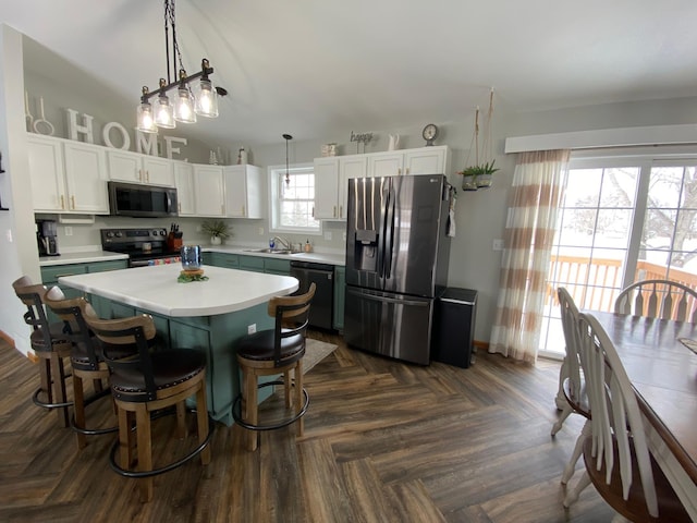 kitchen featuring pendant lighting, sink, appliances with stainless steel finishes, a center island, and white cabinets