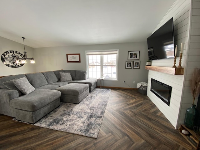 living room with an inviting chandelier, a fireplace, dark parquet floors, and lofted ceiling