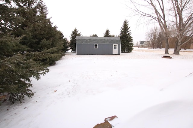 yard covered in snow featuring a storage shed