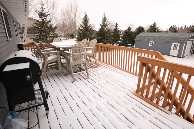 snow covered deck with a storage unit