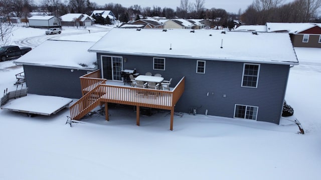 snow covered back of property featuring a wooden deck