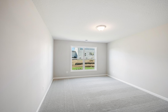 carpeted spare room with a textured ceiling