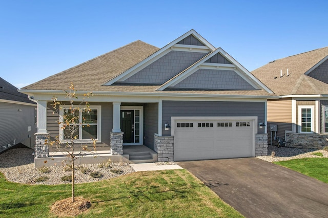 craftsman inspired home with a garage, covered porch, and a front yard