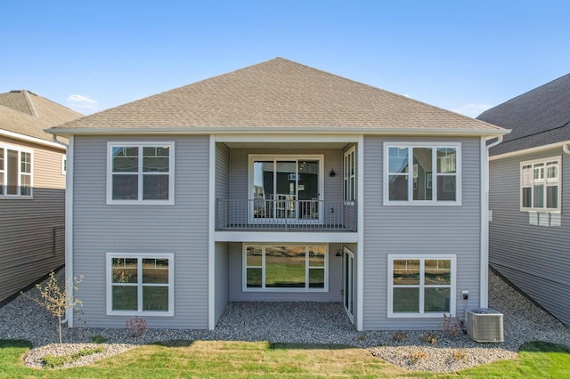 back of property with central AC unit and a balcony