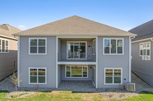 back of property with cooling unit and a balcony