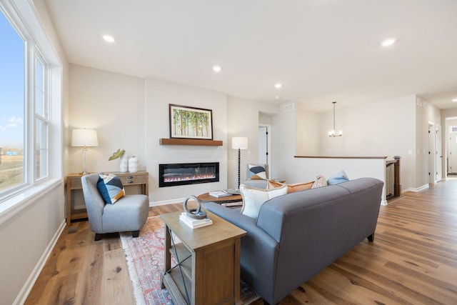 living room with light hardwood / wood-style flooring and a chandelier