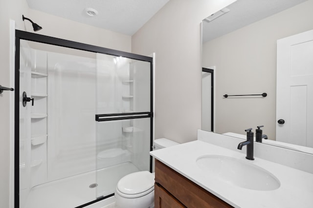 bathroom with vanity, toilet, an enclosed shower, and a textured ceiling