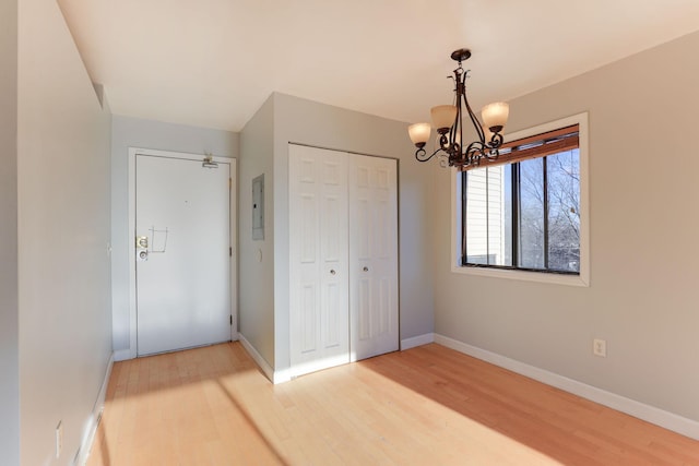 unfurnished bedroom featuring wood-type flooring, a chandelier, and a closet