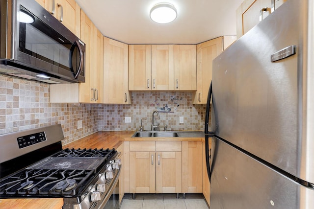 kitchen featuring wood counters, sink, stainless steel appliances, and light brown cabinets