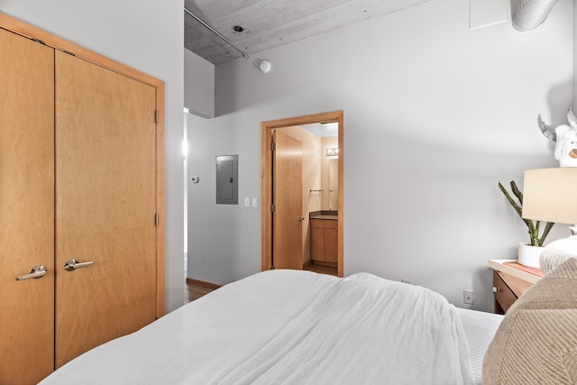 bedroom featuring connected bathroom and electric panel