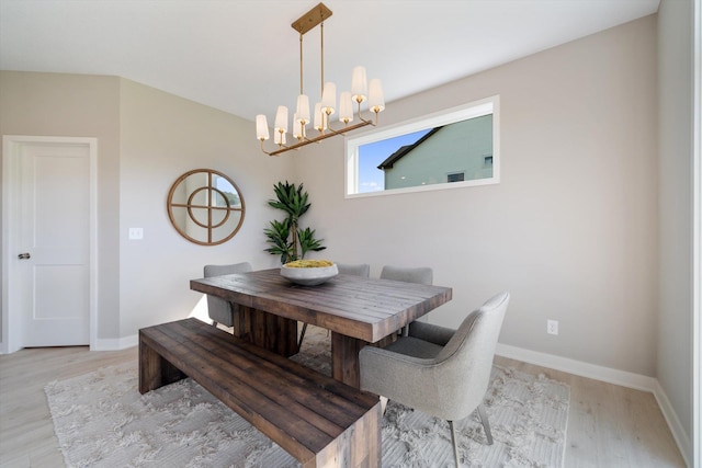 dining area with a chandelier and light hardwood / wood-style flooring