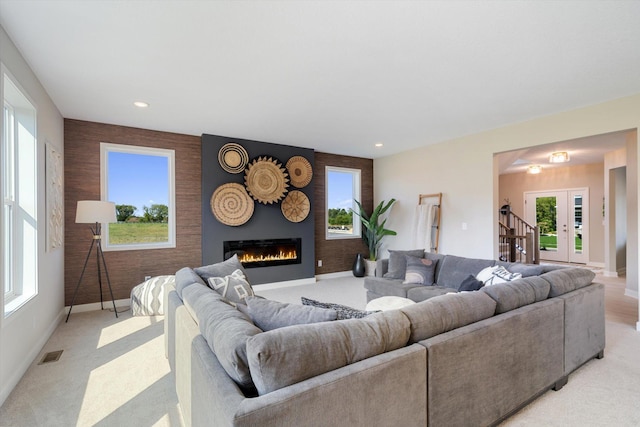 living room featuring light carpet, plenty of natural light, and french doors