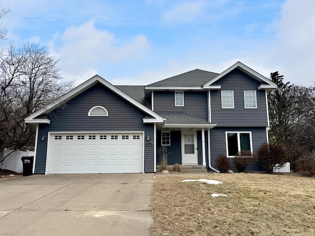 view of property with a garage and a front lawn