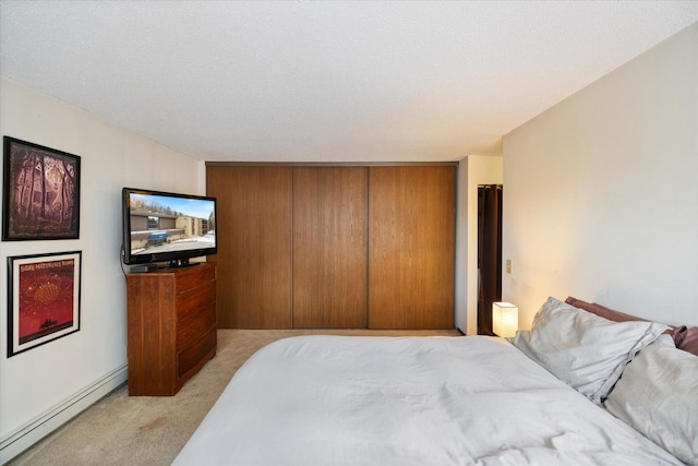 bedroom with a baseboard radiator and light colored carpet