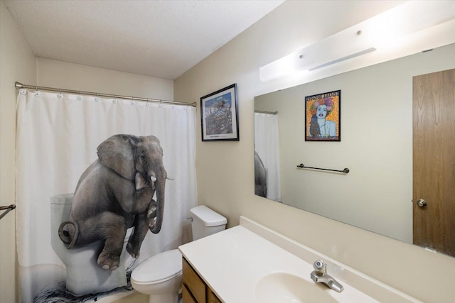 bathroom featuring vanity, a textured ceiling, and toilet