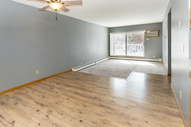 empty room featuring ceiling fan, a wall mounted AC, baseboards, and wood finished floors