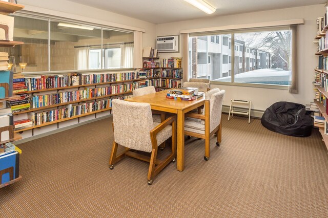 carpeted dining area with a wall mounted AC and a baseboard radiator