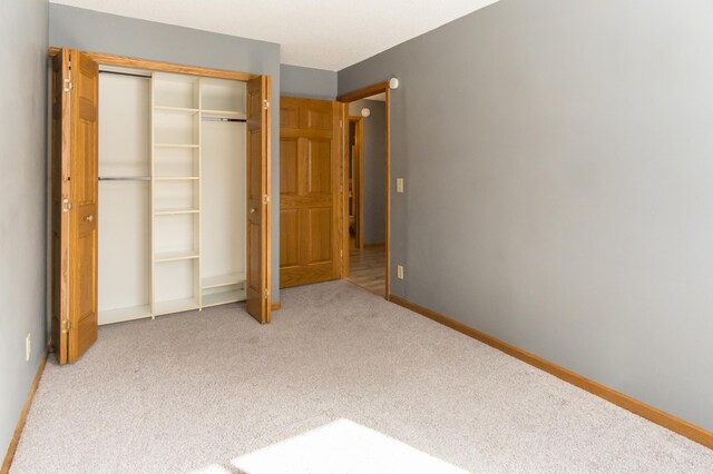 unfurnished bedroom featuring a closet, carpet flooring, and baseboards