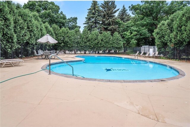 community pool featuring fence and a patio