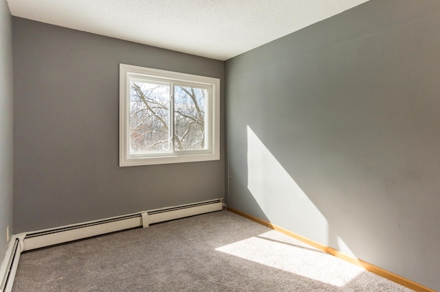 carpeted empty room featuring a textured ceiling, a baseboard radiator, and baseboards