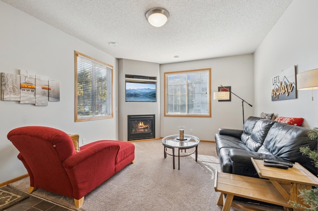 living room featuring a healthy amount of sunlight, dark carpet, and a textured ceiling