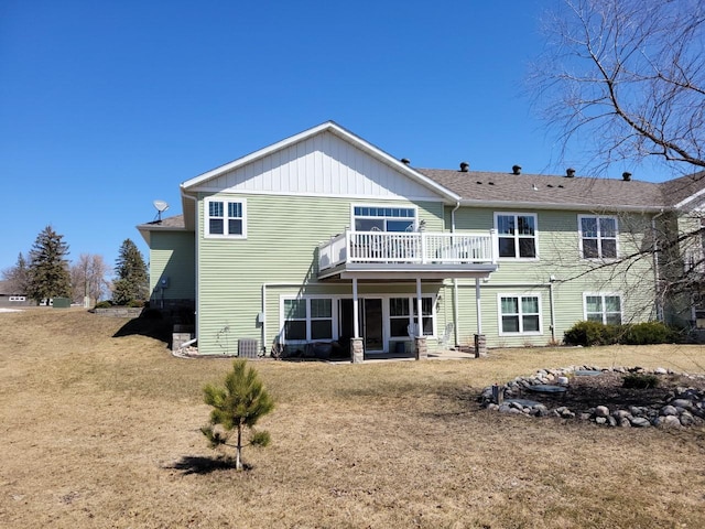 back of house featuring central AC unit, a lawn, and a sunroom