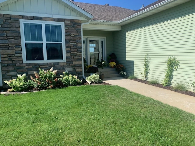 view of exterior entry with a yard