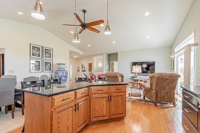 kitchen featuring lofted ceiling, a center island, light hardwood / wood-style floors, and hanging light fixtures