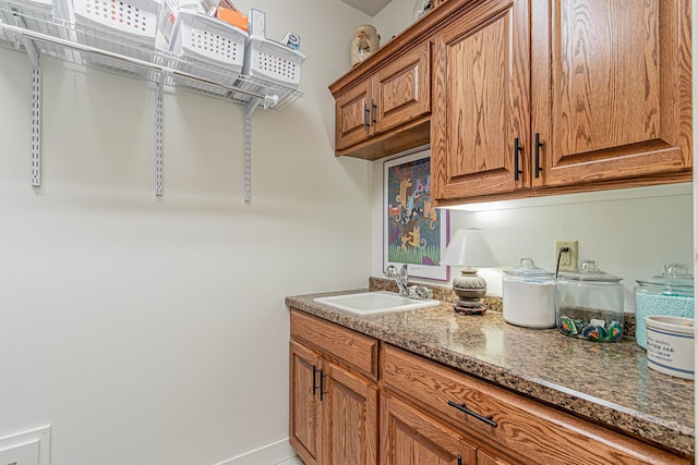 interior space with sink and dark stone counters