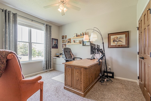 carpeted office featuring a textured ceiling and ceiling fan