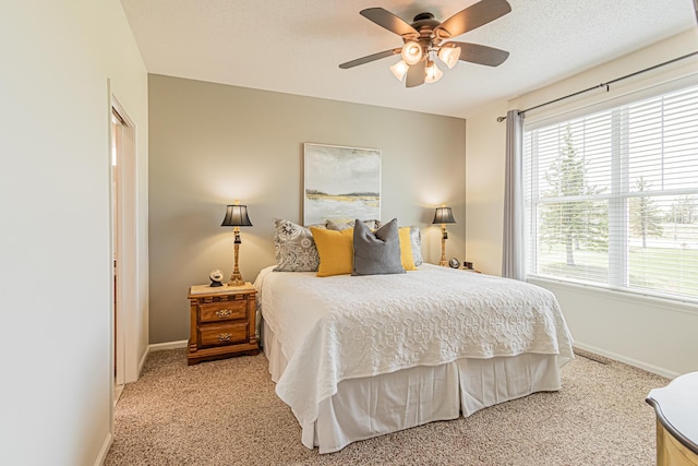 bedroom with ceiling fan, light carpet, and a textured ceiling