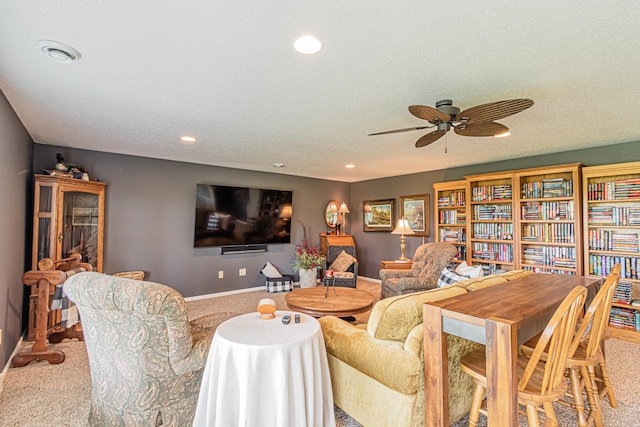 carpeted living room featuring ceiling fan and a textured ceiling