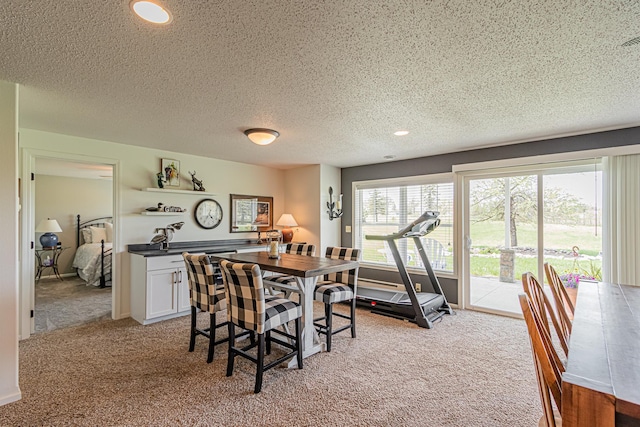 dining space with light colored carpet and a textured ceiling