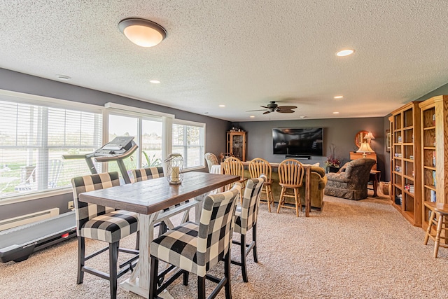 dining room with ceiling fan, light colored carpet, plenty of natural light, and a textured ceiling