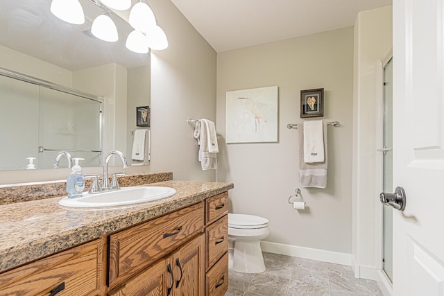 bathroom featuring vanity, a shower with shower door, and toilet