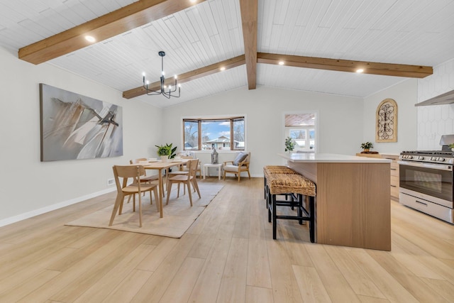 dining space featuring lofted ceiling with beams, a chandelier, and light wood-type flooring