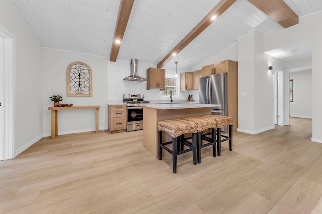 kitchen featuring wall chimney exhaust hood, hanging light fixtures, light hardwood / wood-style flooring, a kitchen island, and stainless steel appliances