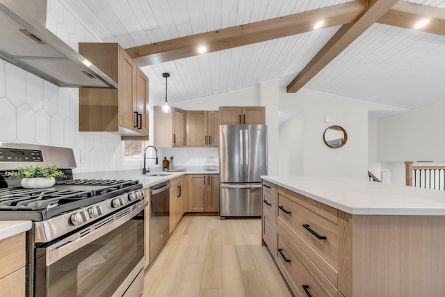 kitchen with sink, hanging light fixtures, a center island, stainless steel appliances, and wall chimney exhaust hood