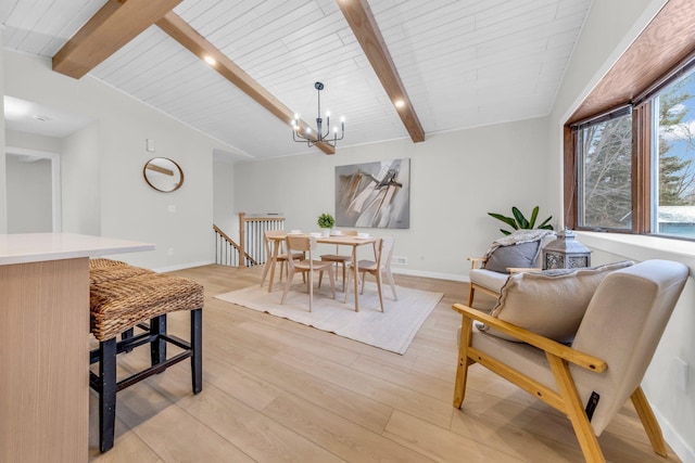 dining room featuring vaulted ceiling with beams, a chandelier, and light wood-type flooring