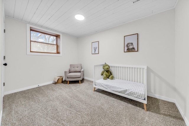 carpeted bedroom featuring wood ceiling and a nursery area