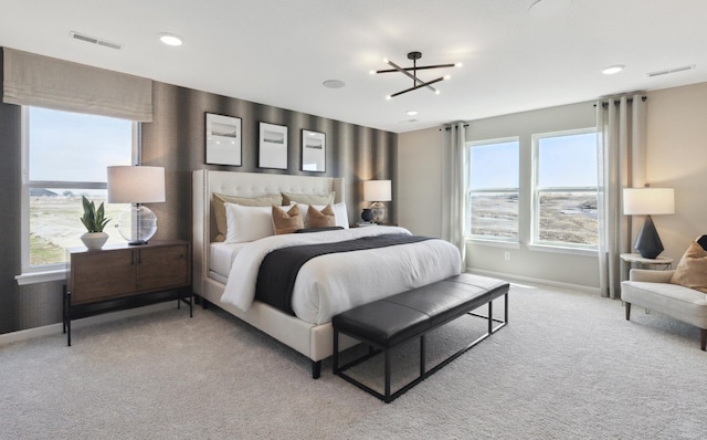 carpeted bedroom featuring multiple windows and a chandelier