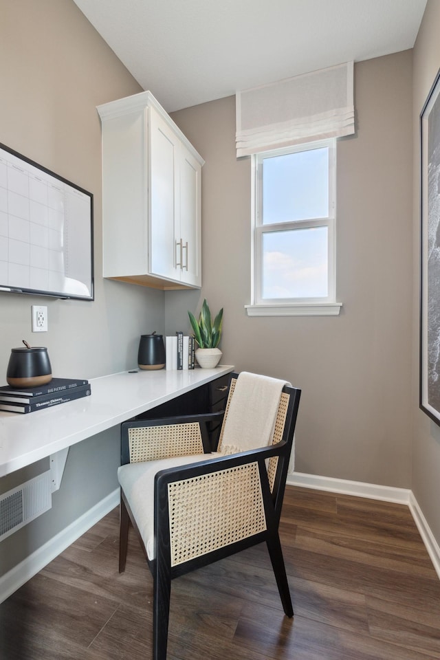 home office featuring built in desk and dark hardwood / wood-style floors