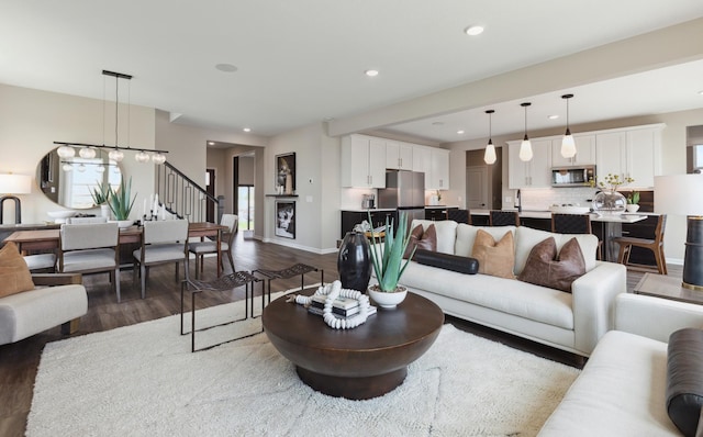 living room featuring wood-type flooring and an inviting chandelier