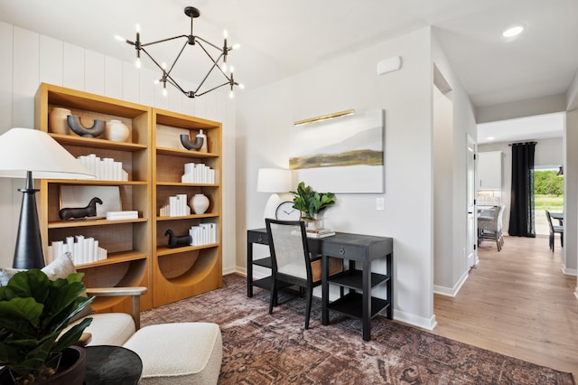 office area featuring an inviting chandelier and hardwood / wood-style floors