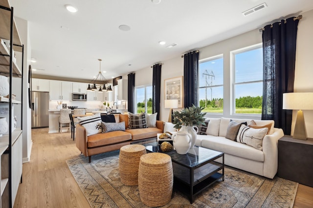 living room featuring an inviting chandelier and light hardwood / wood-style floors