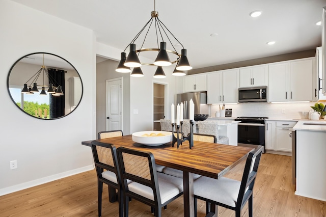 dining space with a notable chandelier and light wood-type flooring