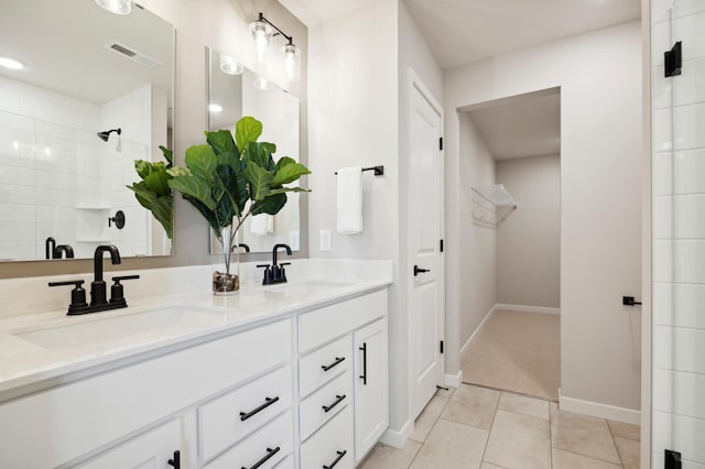 bathroom featuring vanity, tile patterned floors, and tiled shower