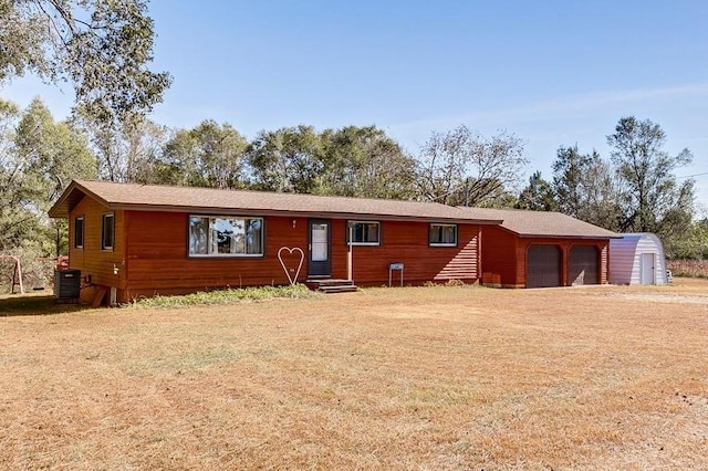 ranch-style home with a garage and central air condition unit