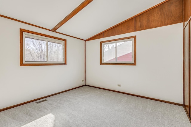 unfurnished room with light colored carpet and vaulted ceiling