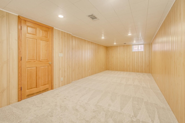 empty room featuring carpet floors and wooden walls